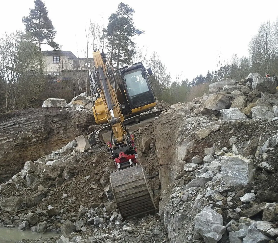 Graving i bakke med gravemaskin